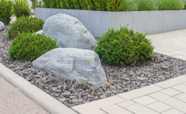 Use a base of gravel and concrete to keep boulders from settling